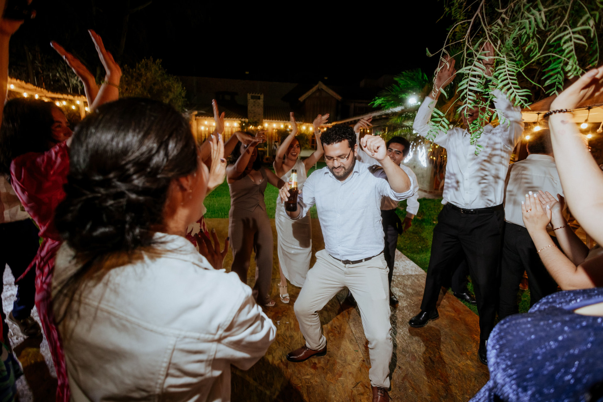 Wedding guests dancing together at an outdoor evening reception